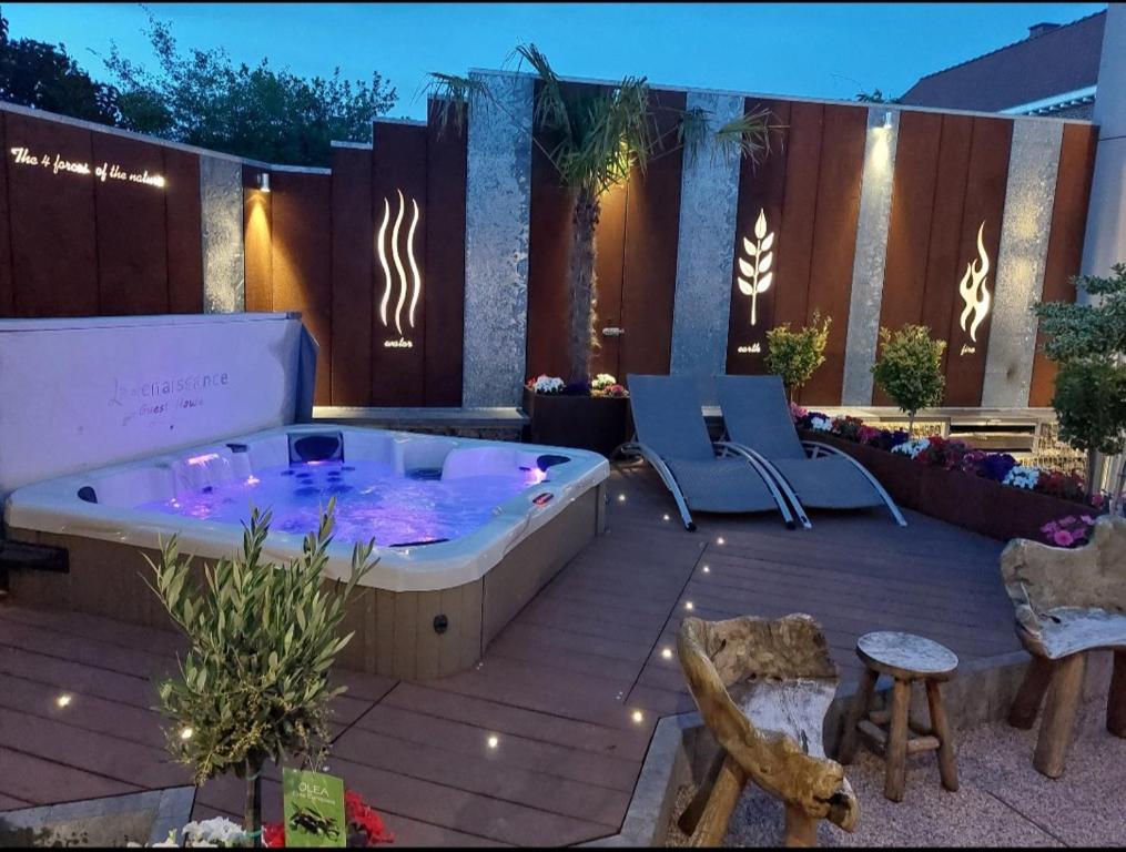 un jacuzzi en un patio con 2 sillas en La Renaissance 1&2 high standing guest house, en Herve