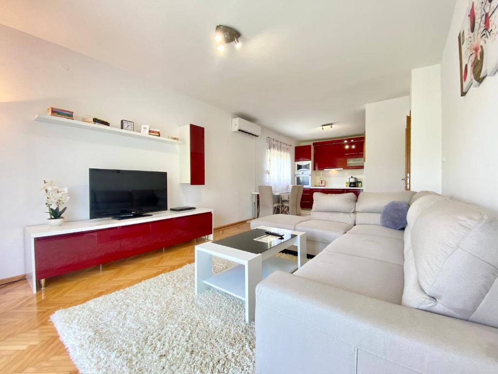 a living room with a white couch and a flat screen tv at Guest House Ivano in Mostar