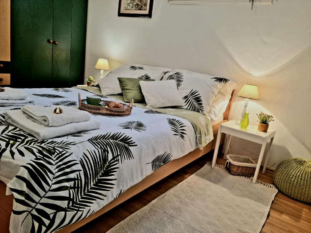 a bedroom with a bed with a black and white blanket at Biba Apartman in Petrcane