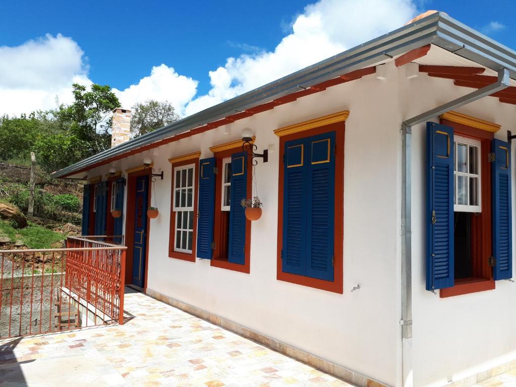 a house with blue and red shutters on it at Solar dos Reis Apartamento Topázio in Ouro Preto