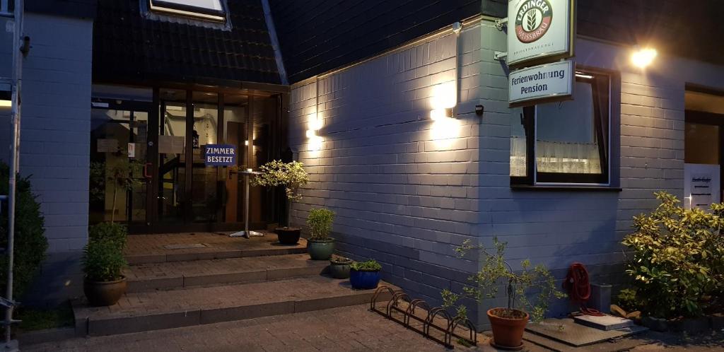 un edificio azul con escaleras delante en Pension Strohm im Lieth Café en Bad Fallingbostel