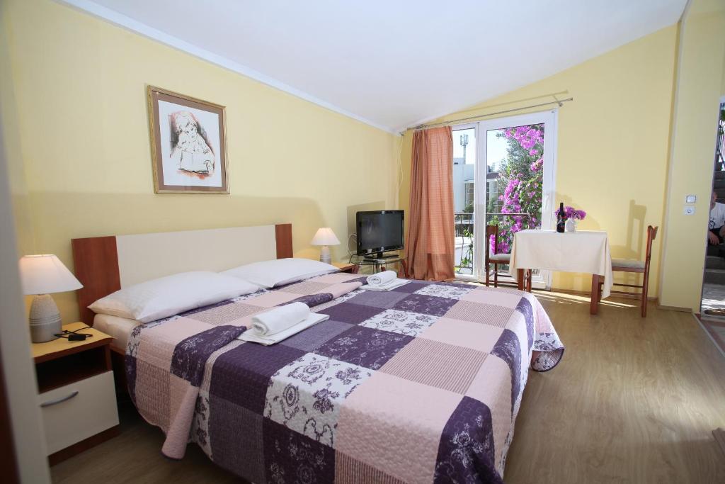 Schlafzimmer mit einem Bett, einem Tisch und einem Fenster in der Unterkunft Apartments Kovačić in Makarska