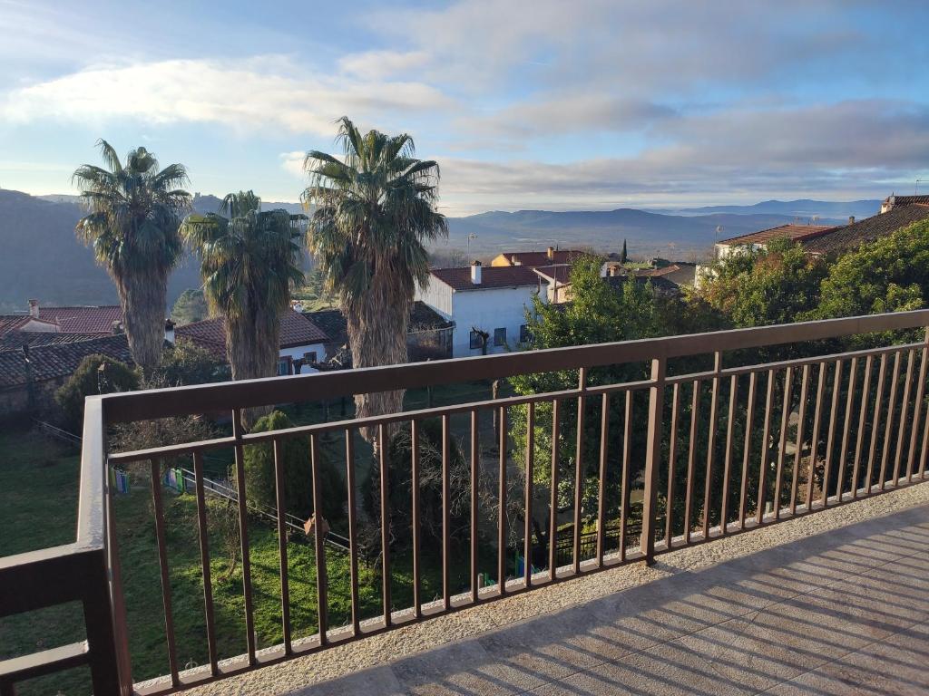 a balcony with a fence and palm trees at Apartamento Buenavista in Villamiel