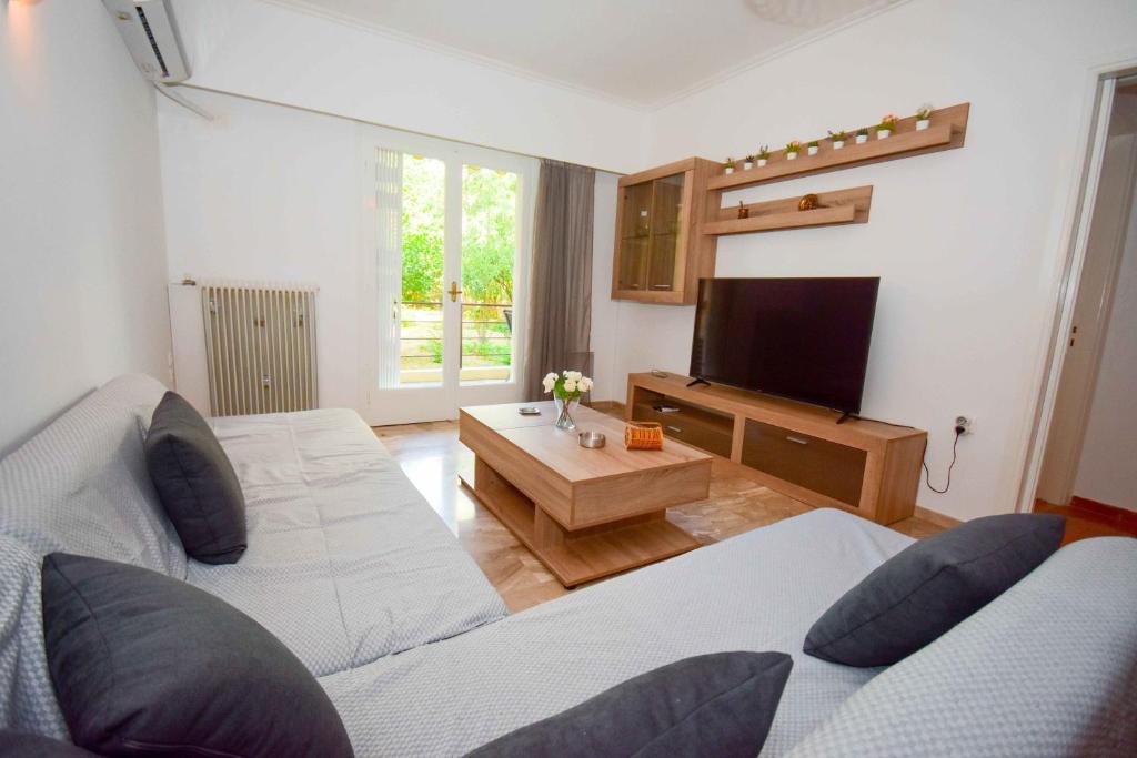 ein Wohnzimmer mit 2 Betten und einem Flachbild-TV in der Unterkunft Filoxenia Apartment Athens in Athen