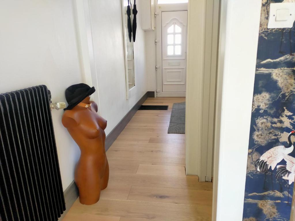 une statue d'une femme debout dans un couloir dans l'établissement Le 32, à Lens