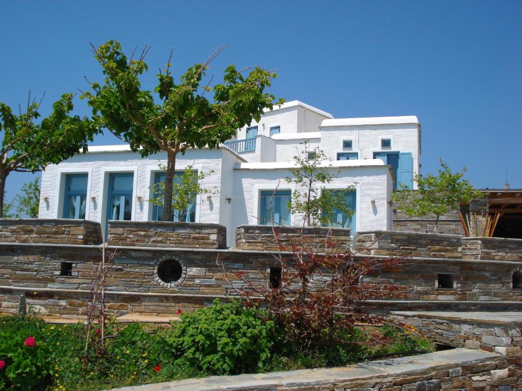 una casa blanca sentada en la parte superior de una pared de piedra en Cavo Lacia, en Gavrion