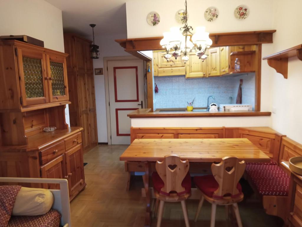 a kitchen with wooden cabinets and a wooden table and chairs at Stella alpina in Sappada