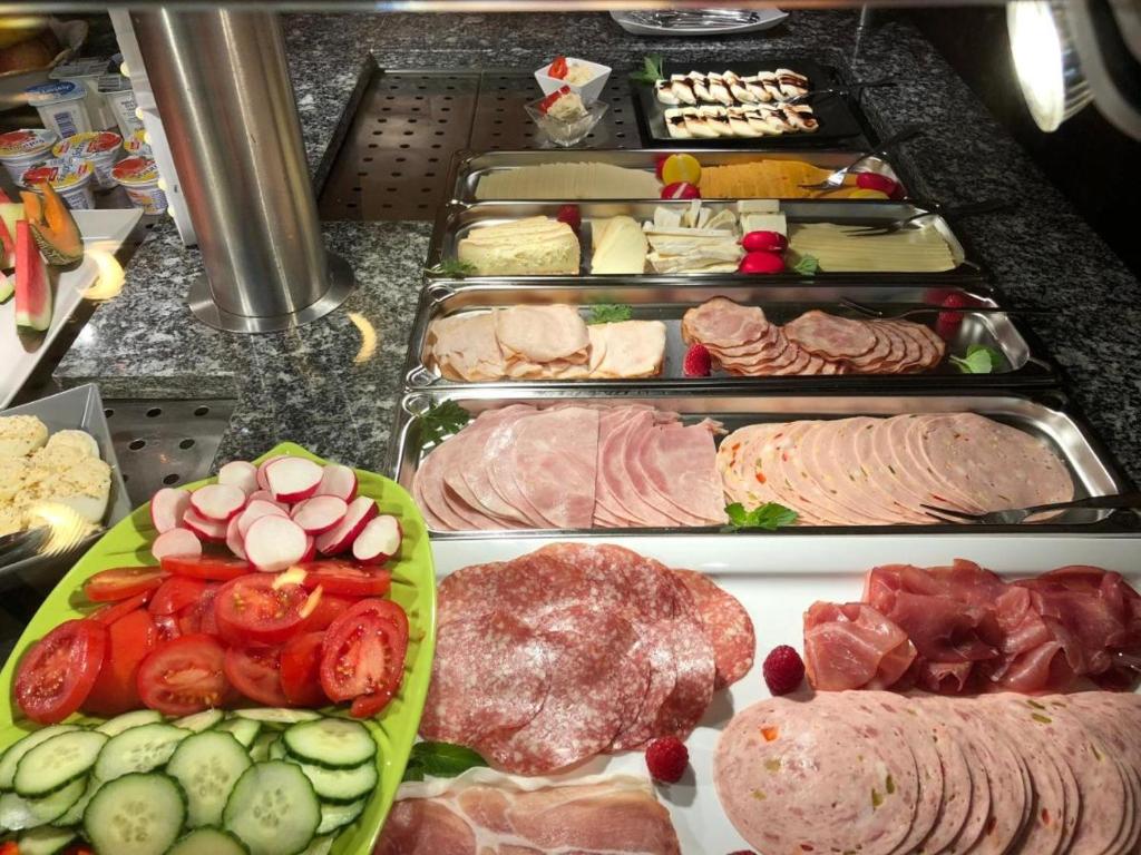 ein Buffet mit verschiedenen Arten von Fleisch und Gemüse in der Unterkunft Hotel Blüchertal Bacharach in Bacharach