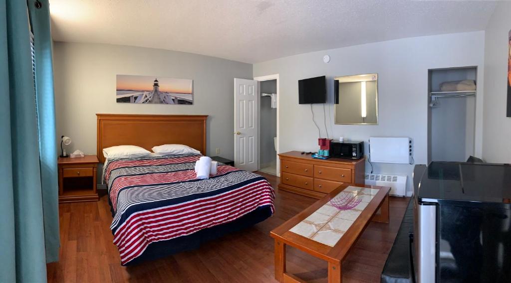 Habitación pequeña con cama y mesa en Wasaga Motel Inn, en Wasaga Beach