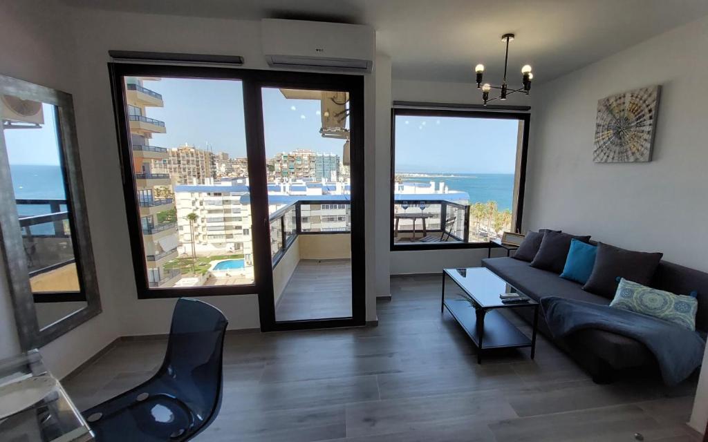 salon z kanapą i widokiem na ocean w obiekcie Aloha Beach Vibe w mieście Benalmádena