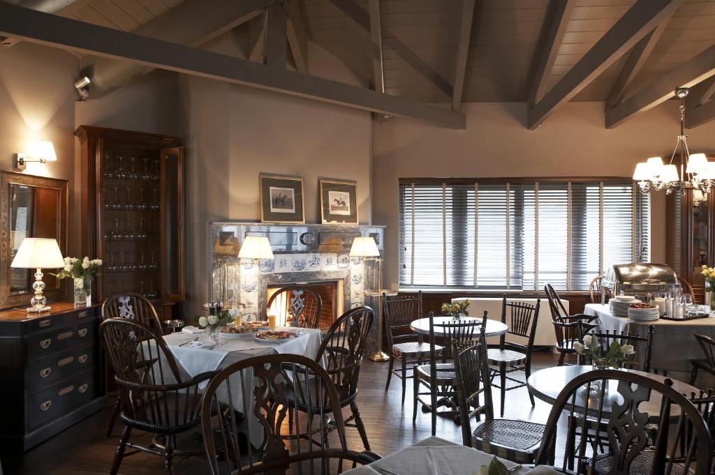 a dining room with tables and chairs and a fireplace at Aegli Arachova in Arachova