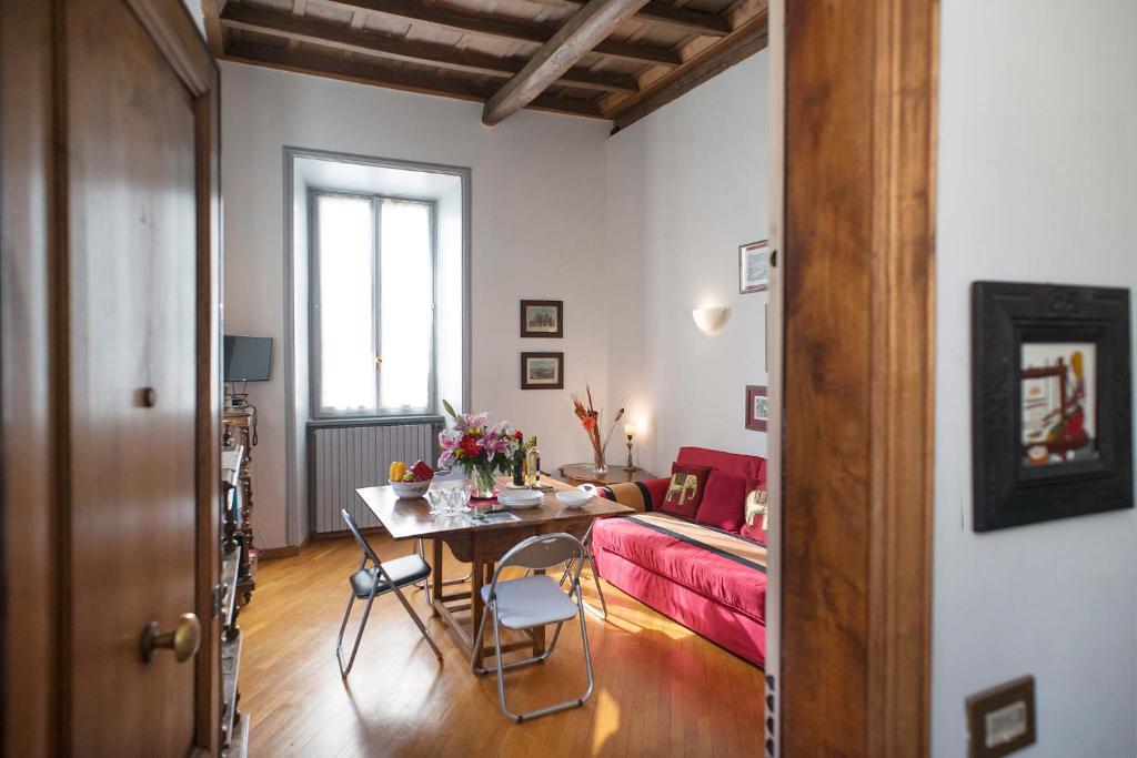 a living room with a table and a bed at Bilocale nel cuore del quartiere ebraico in Rome