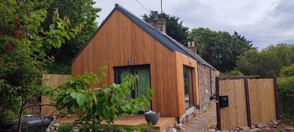 a wooden house with a fence in front of it at Stonehaven 2 Bedroom Seaside Cottage with Garden in Stonehaven