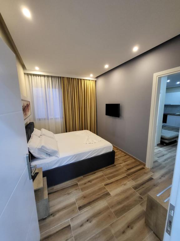 een slaapkamer met een bed en een televisie aan de muur bij DelMar Apartments in Golem