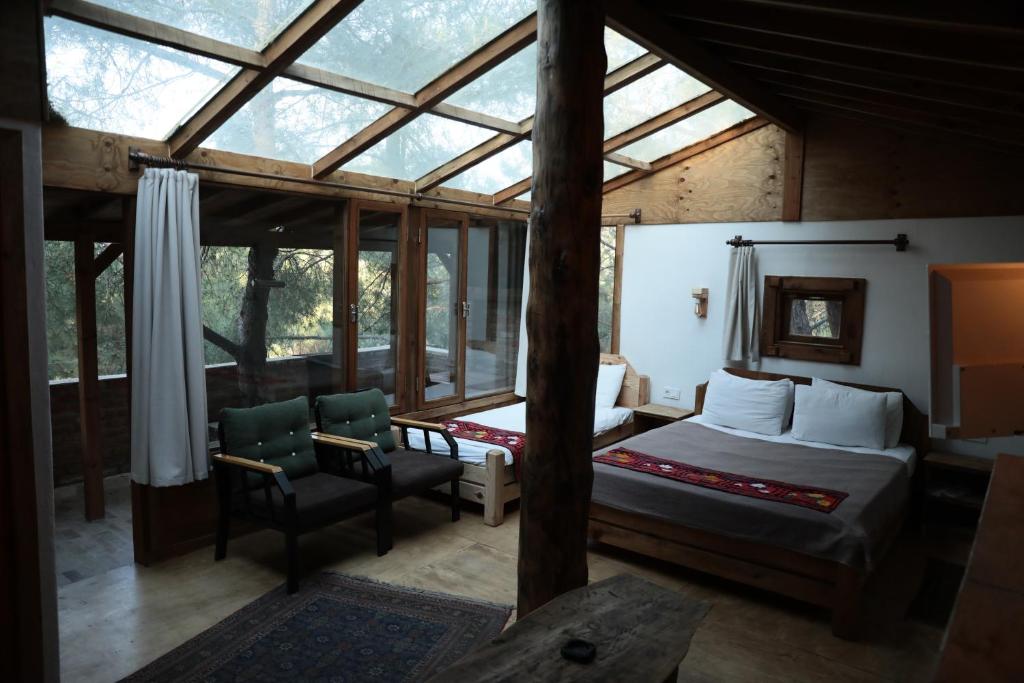 une chambre avec un lit et une chaise dans une pièce dans l'établissement Kayserkaya Cottages, à Selçuk