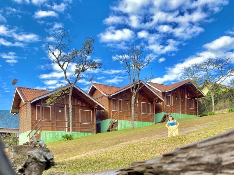 Eine Frau, die auf einem Stuhl vor einem Haus sitzt. in der Unterkunft Chalés Eucaliptos in Monte Verde