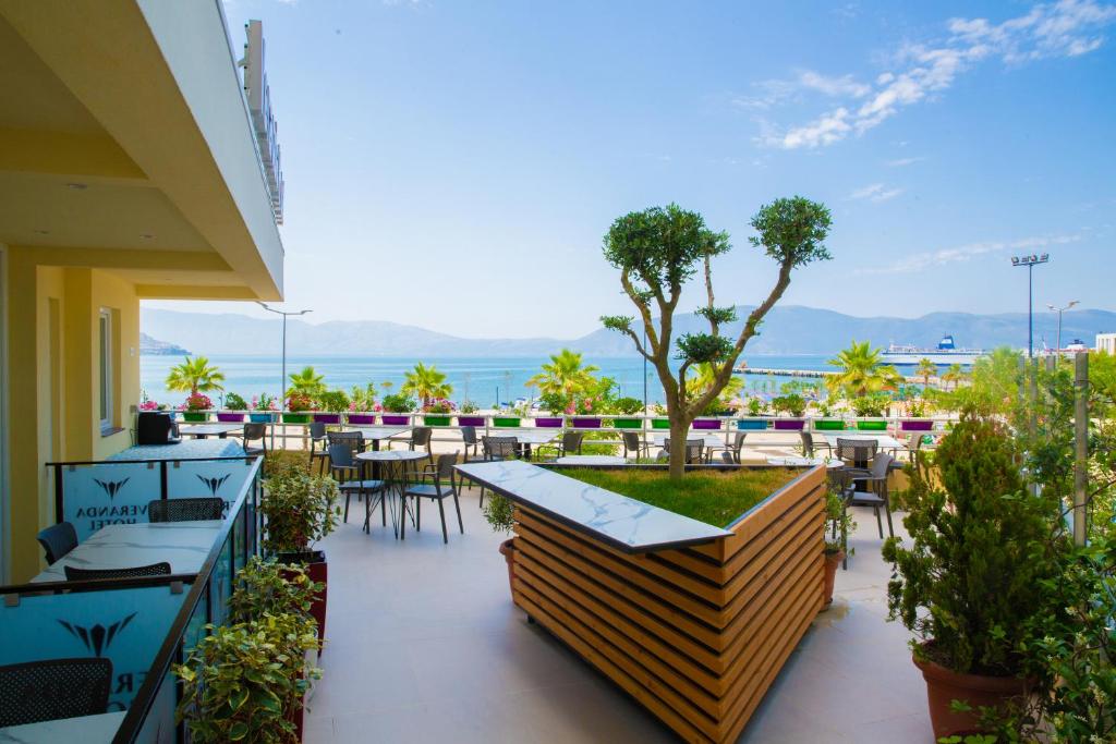 een patio met tafels en stoelen en uitzicht op de oceaan bij Veranda Boutique Hotel in Vlorë