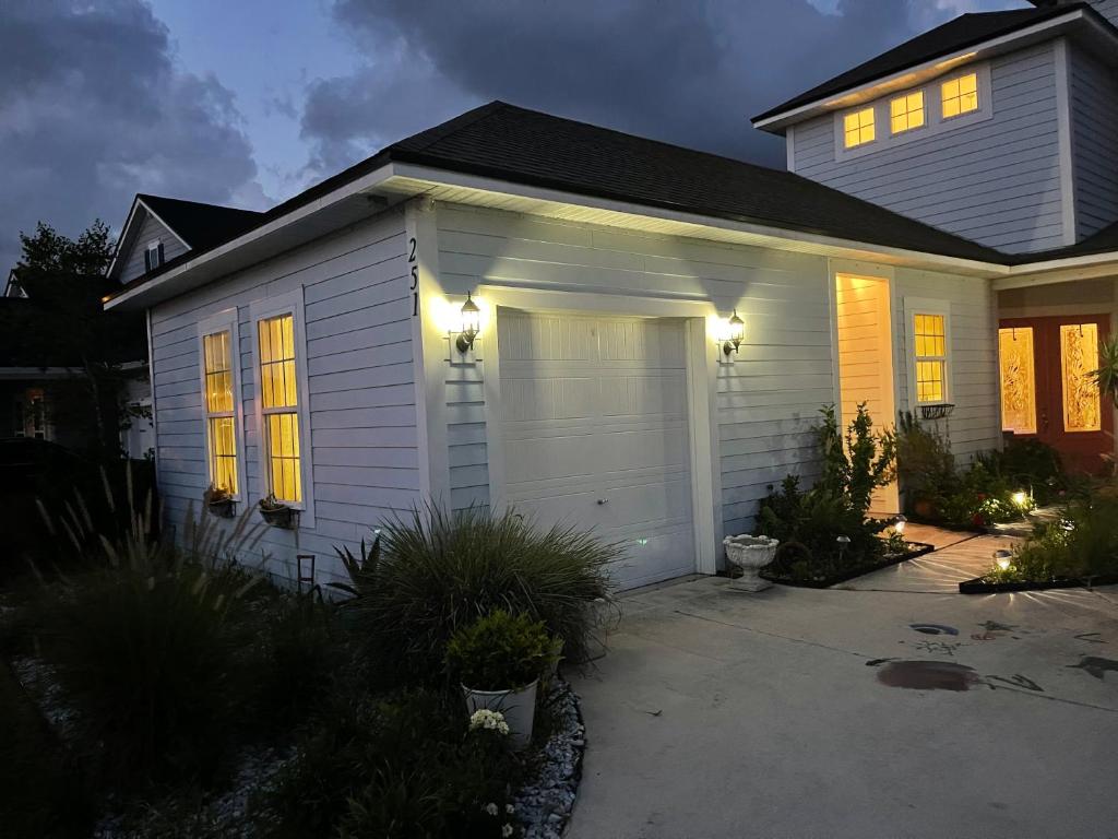 a white house with a garage with lights on it at Apartment Gran Lake in Saint Augustine