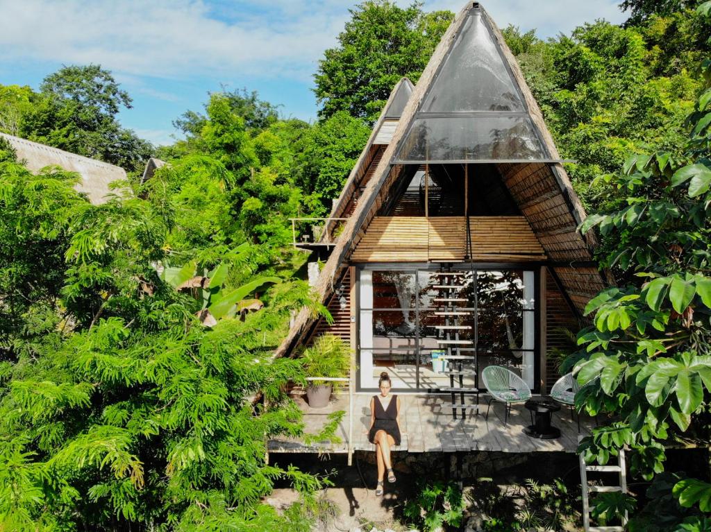 a woman standing in front of a tree house at Azul Nomeolvides in Bacalar