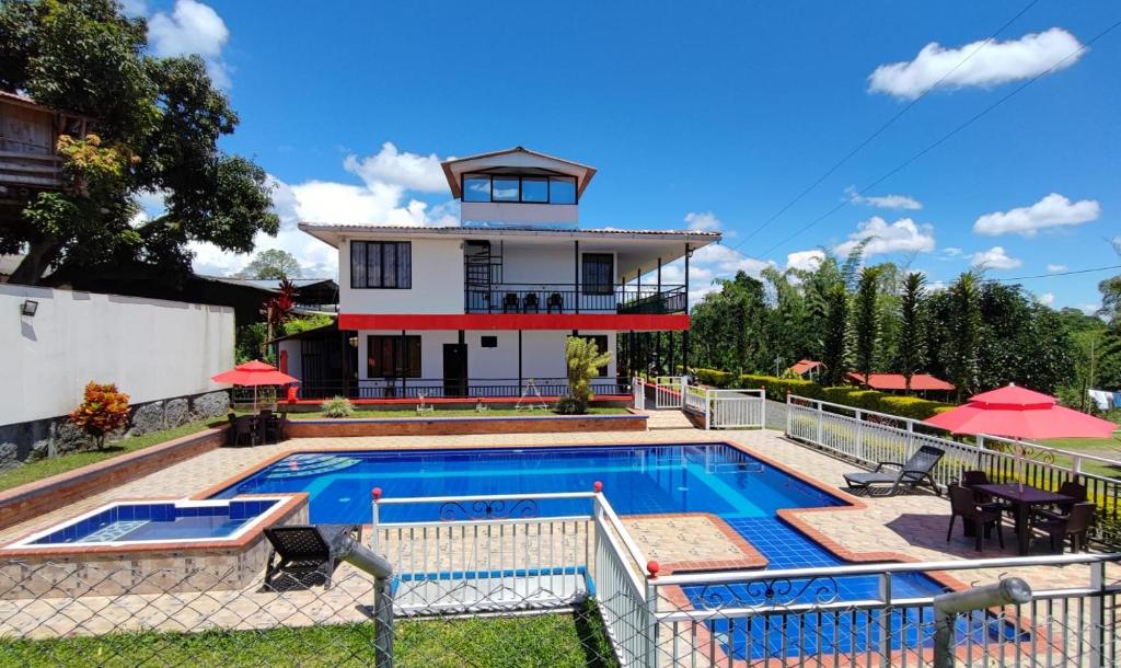 une maison avec une piscine en face d'une maison dans l'établissement Finca Hotel el Guadual, à Quimbaya