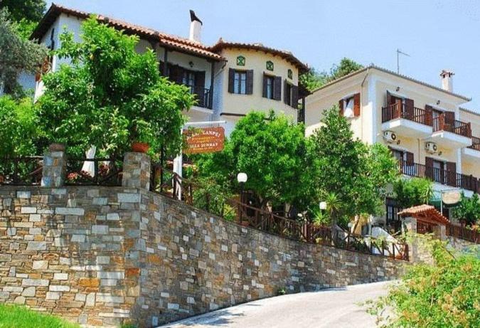 una pared de piedra frente a un edificio en Villa Sunray, en Agios Ioannis