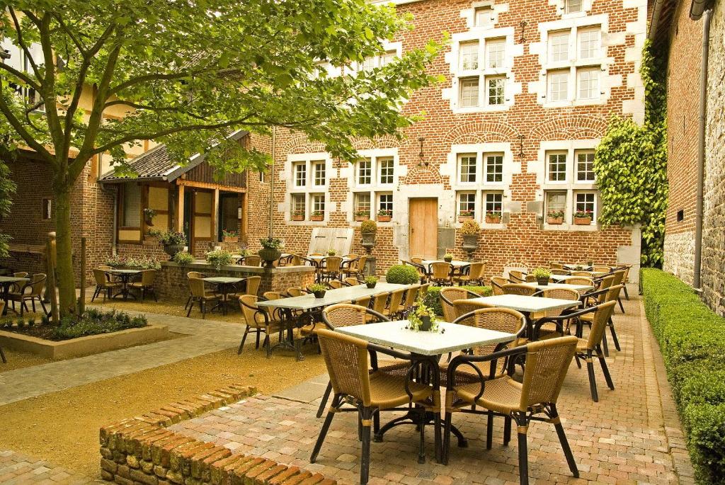 a patio with tables and chairs in front of a building at Blanckthys Hotel Voeren in Voeren