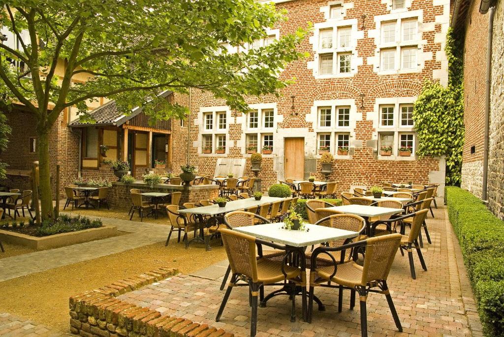 eine Terrasse mit Tischen und Stühlen vor einem Gebäude in der Unterkunft Blanckthys Hotel Voeren in Voeren