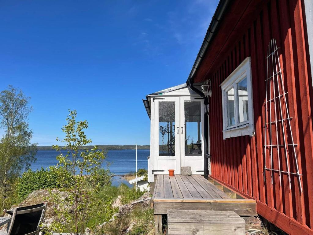 Holiday home Trollhättan II في ترولهاتان: منزل احمر مع منحدر خشبي يؤدي الى الباب