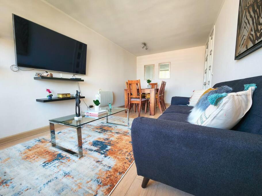 uma sala de estar com um sofá azul e uma mesa em Departamento familiar en plan de Viña del Mar em Viña del Mar