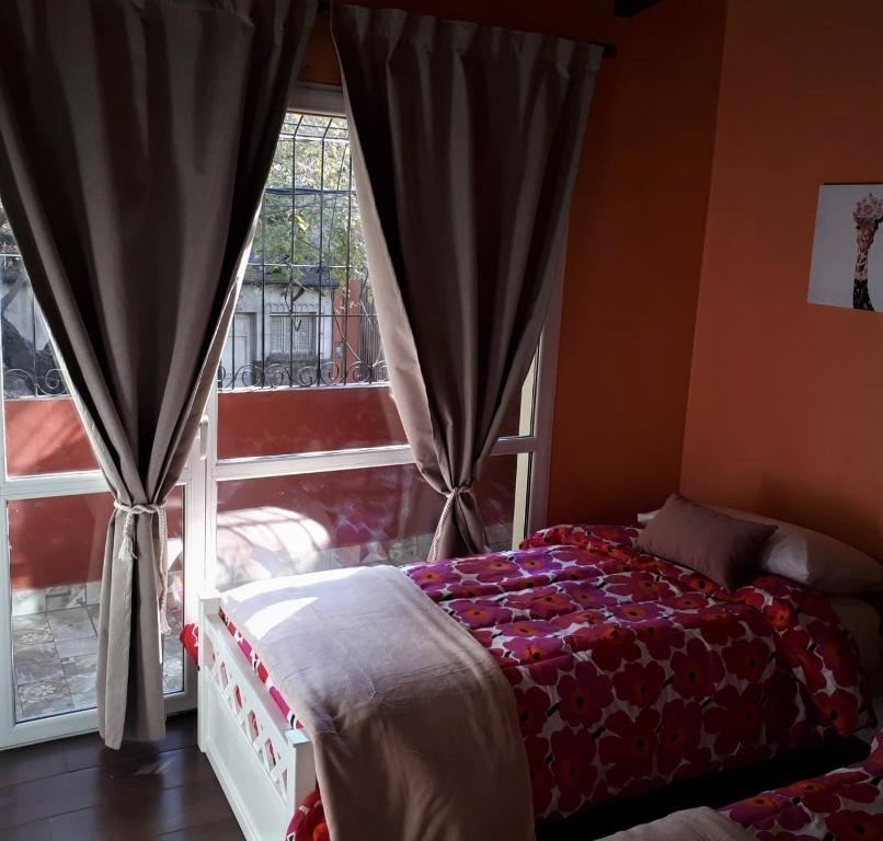 een slaapkamer met een bed voor een raam bij Departamento FAMILY in Mendoza