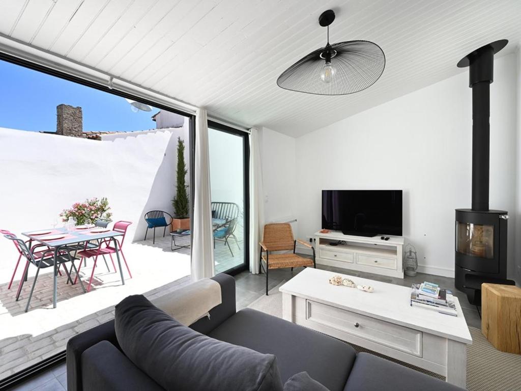 een woonkamer met een bank, een tv en een tafel bij Maison Les Portes-en-Ré, 3 pièces, 4 personnes - FR-1-434-98 in Les Portes