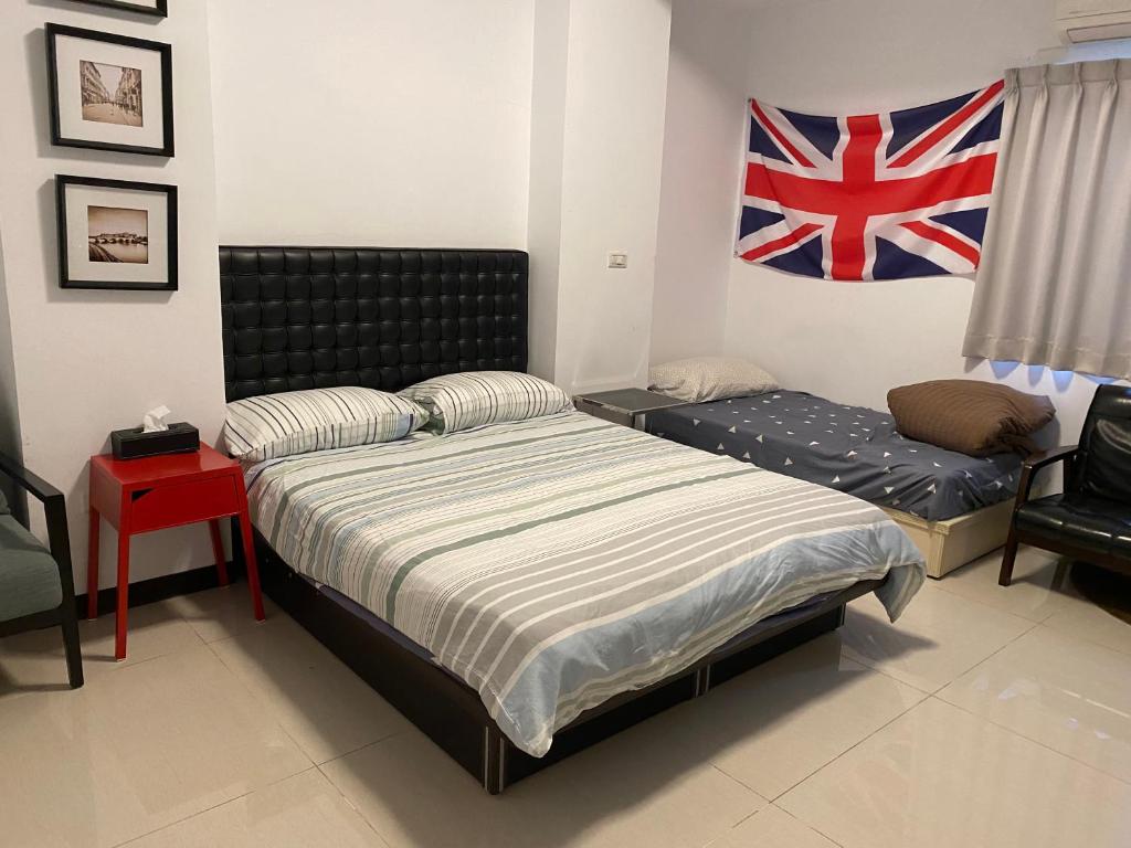 a bedroom with a bed and a chair and a flag at Taichung HSR Homestay in Wuri