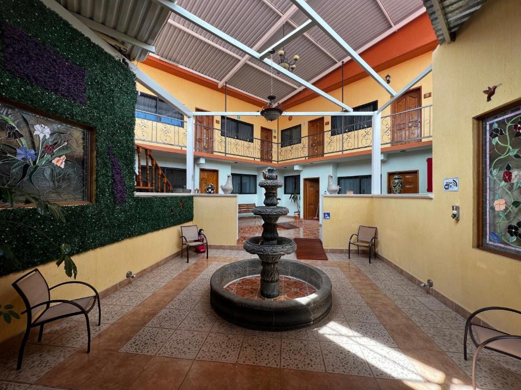 a fountain in the middle of a building with chairs at Hotel Tres Flores in Huasca de Ocampo