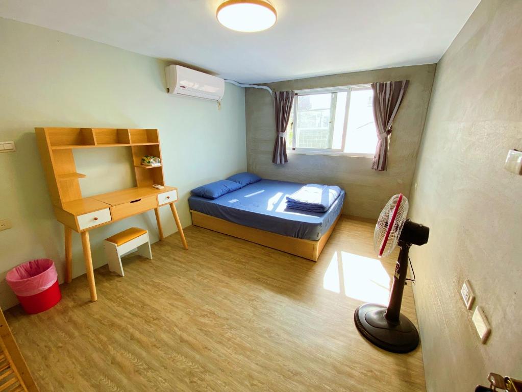 屏東市的住宿－四季小空間，一间小卧室,配有一张床和一张书桌