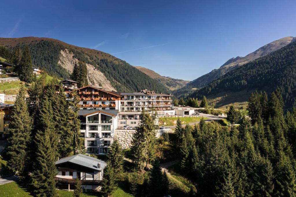 ein Resort in den Bergen mit Bäumen in der Unterkunft URSPRUNG Panorama Hotel Königsleiten in Königsleiten