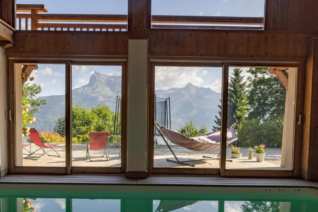 ein Fenster mit einer Hängematte und Bergblick in der Unterkunft Ferme de Faustine 2 - piscine in Saint-Gervais-les-Bains