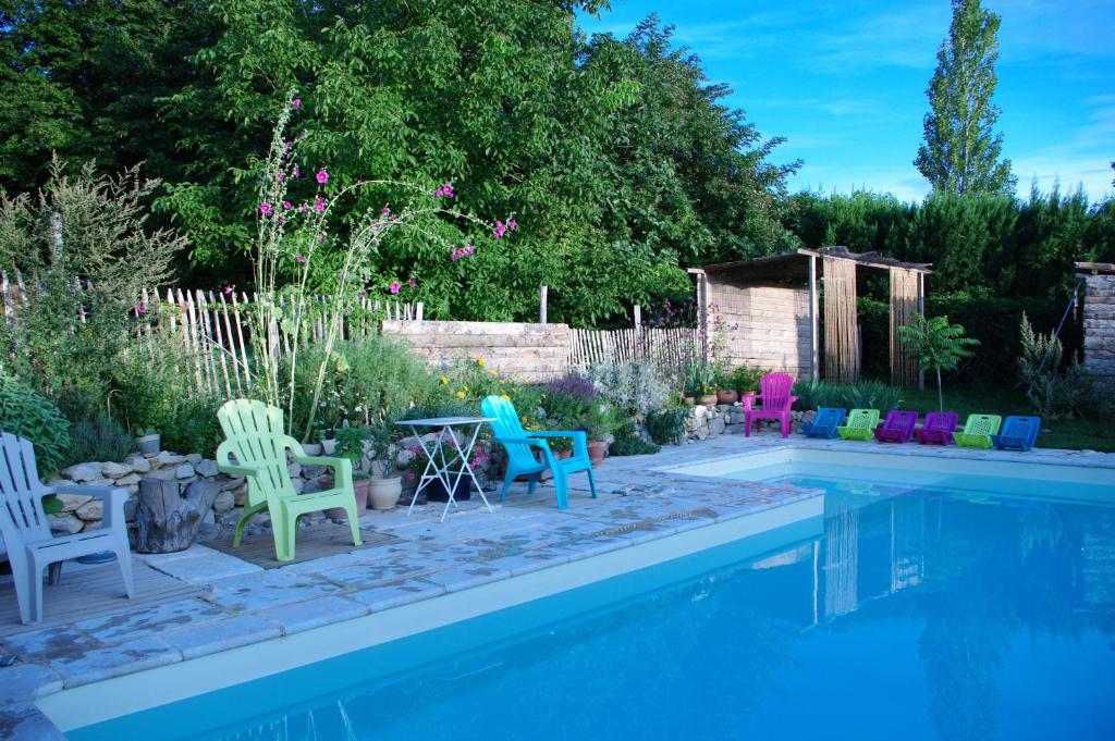 einen Garten mit Stühlen und einem Pool in der Unterkunft Maison d'Hôtes Lou Cliou in Cliousclat