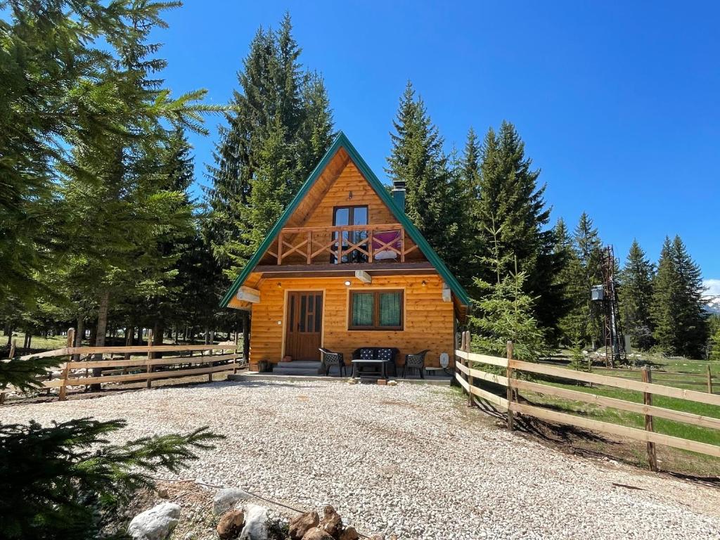 una cabaña en el bosque con una valla en Ville Uskoci, en Žabljak