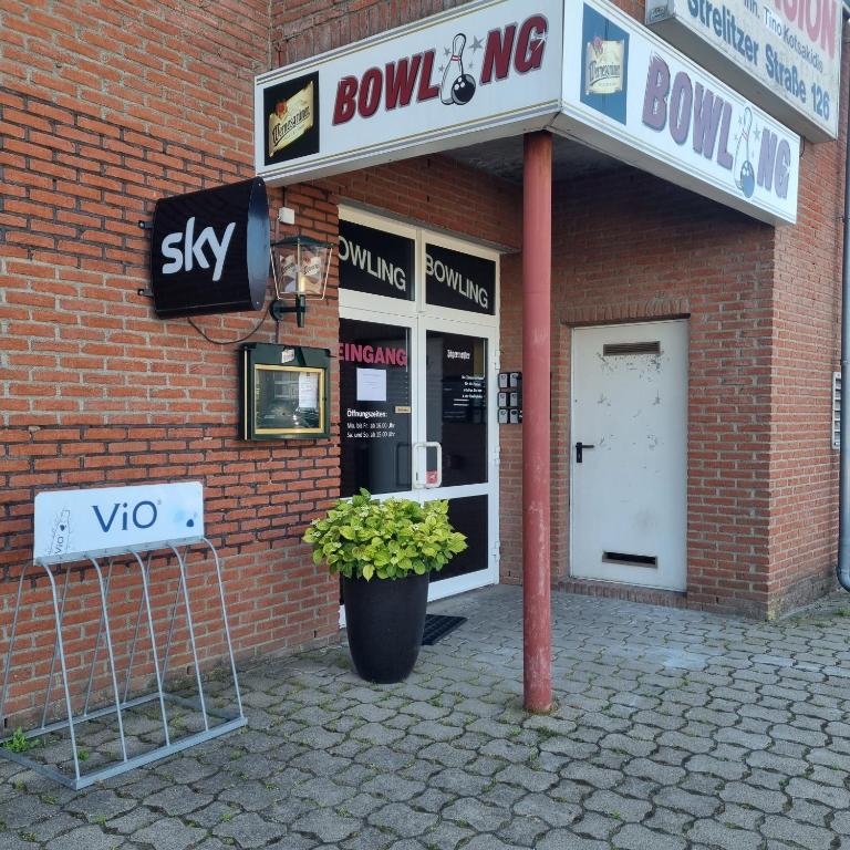 a brick building with a door and a potted plant in front at Müritz-Pension Waren in Waren