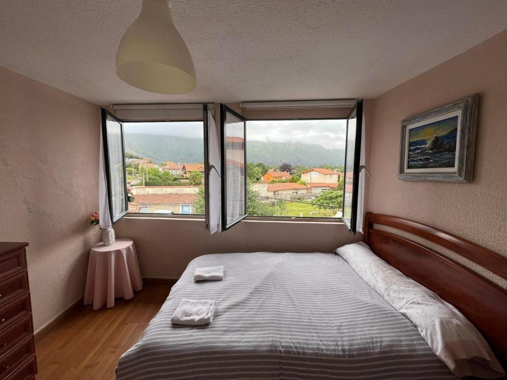 ein kleines Schlafzimmer mit einem Bett und zwei Fenstern in der Unterkunft ApartamentosArturo CasaRural Pancarale-Llanes in Llanes