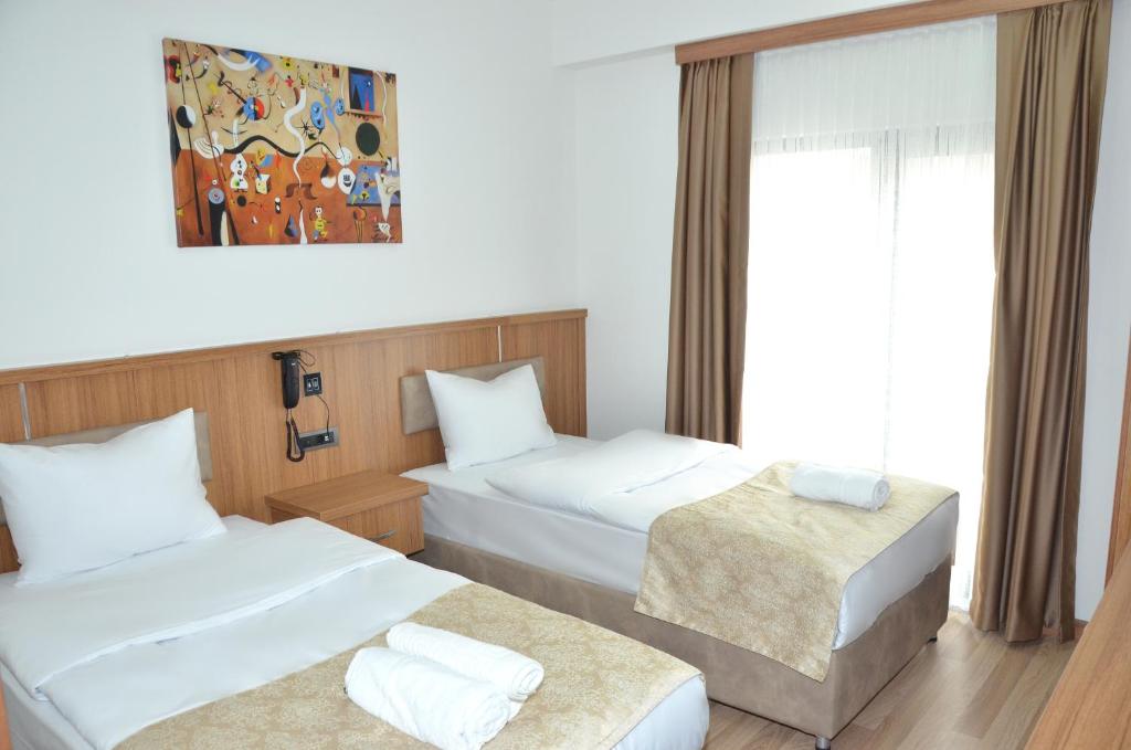una camera d'albergo con due letti e una finestra di Hotel La SERA a Istanbul
