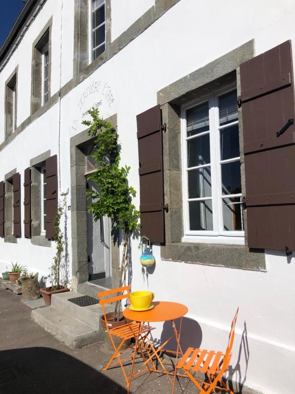 uma mesa e cadeiras em frente a um edifício em La Dernière Étape em Port-Launay