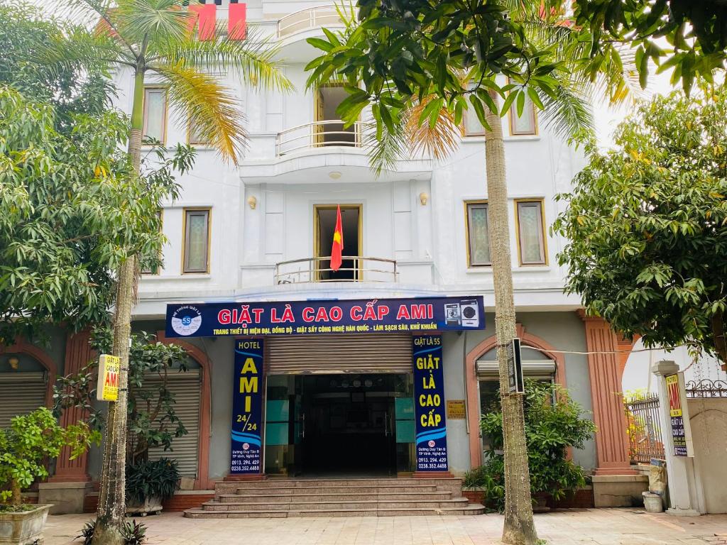 a white building with a sign in front of it at Khách sạn AMI in Vinh