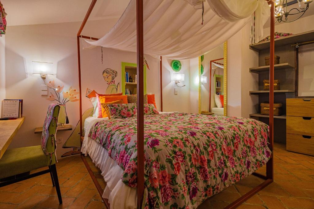 a bedroom with a canopy bed and a desk at Cerrado das Fontainhas in Almargem do Bispo