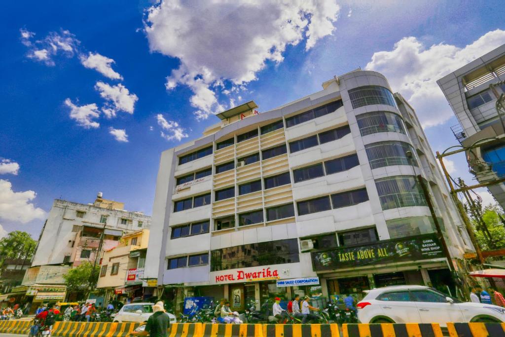 un grande edificio bianco su una strada di città con le auto di Hotel Dwarika Inn a Indore