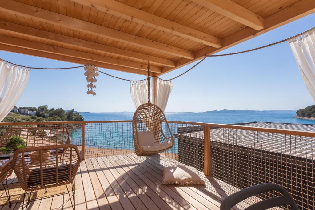 eine Veranda mit einer Schaukel und Meerblick in der Unterkunft Mara's Coast - Dalia in Drage