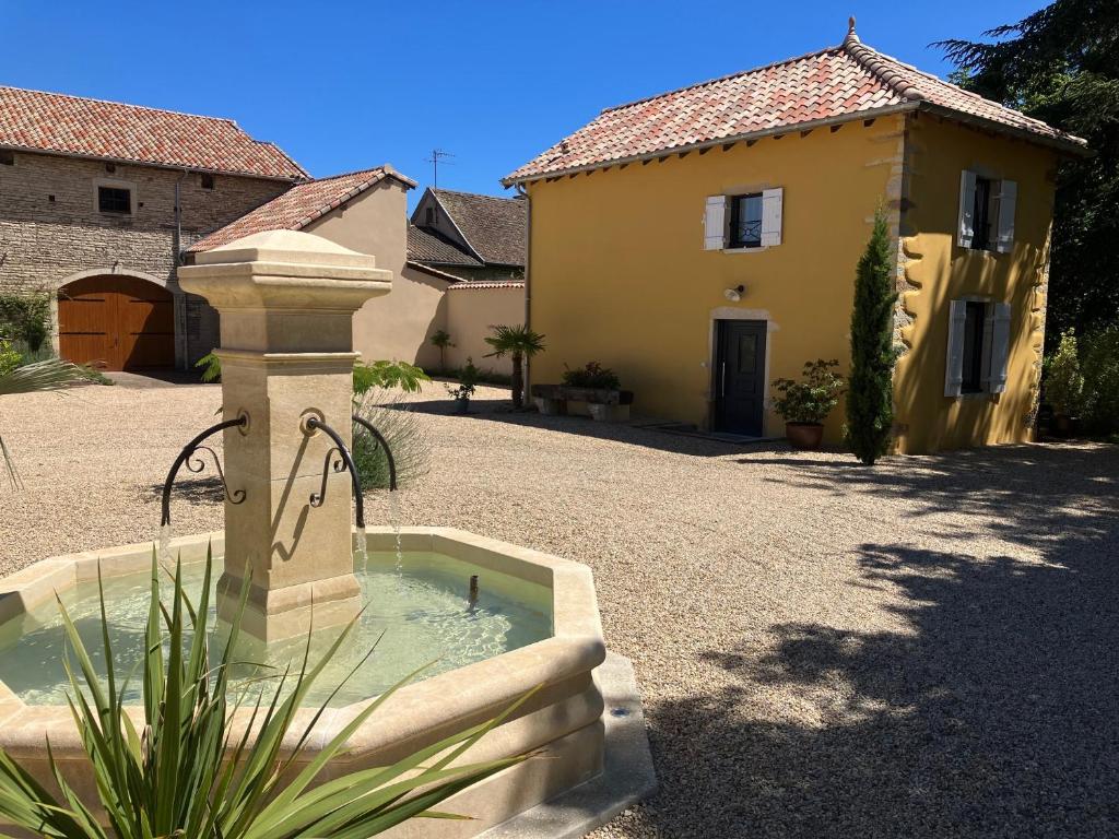 a water fountain in a yard next to a house at Le Clos De Quintaine Gîtes de Charme in Clessé