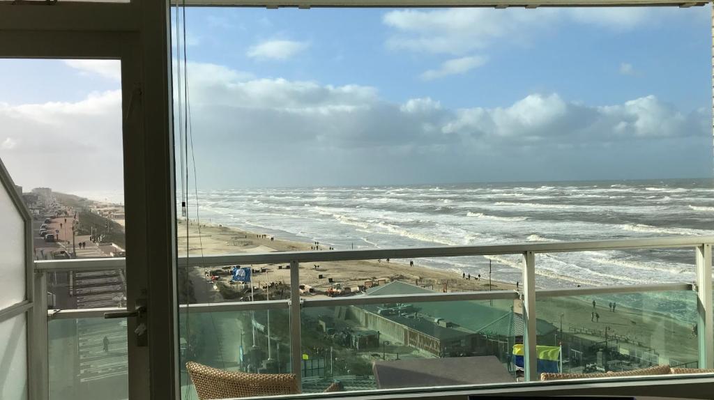 a view of a beach from a window at Dreamview Apartment in Zandvoort