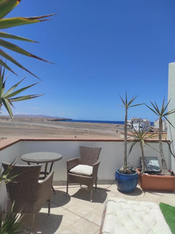 a patio with a table and chairs and the beach at Laylas Beach Art House in El Cotillo