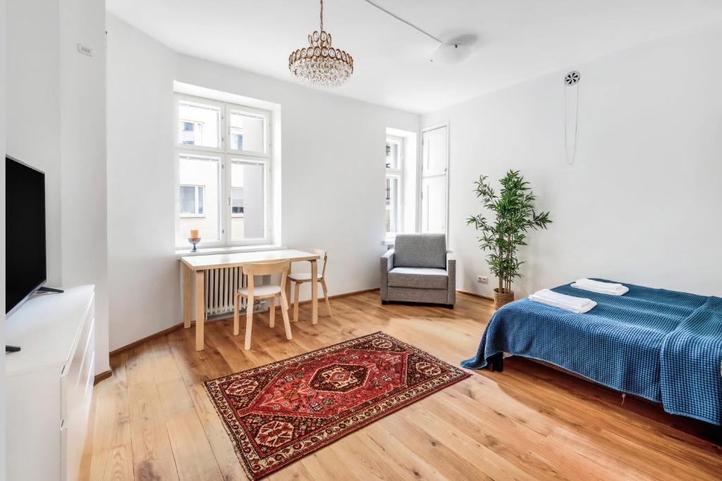 a bedroom with a bed and a table with a chair at WeHost Oikokatu in Helsinki